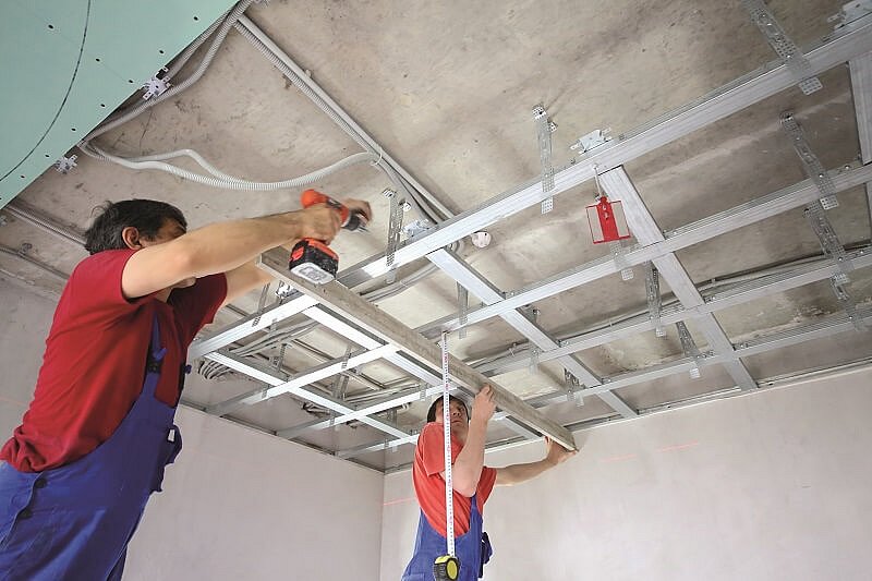 Bauarbeiter bei Installation von Materialien an der Decke