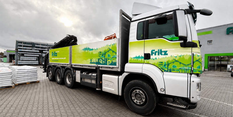 Grün weißer LKW auf einem Parkplatz bei schlechten Wetter